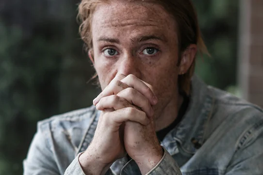 Man with hands clasped suffering anxiety
