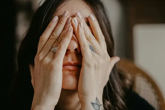 Woman covering her face struggling with childhood trauma